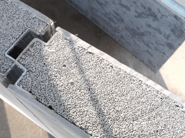 Painel estrutural com núcleo em Concreto Celular, faces em placa cimentícia e encaixes metálicos.